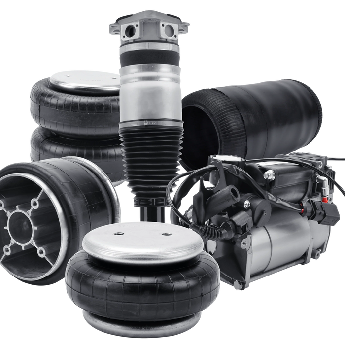 ssortment of air suspension components including air springs, a shock absorber, and an air compressor, arranged against a partially striped gray and white background