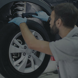 Mechanic inspecting car suspension