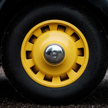 Classic vehicle wheel with a yellow hubcap showing the type of wheel assembly where air springs could be integrated for improved suspension