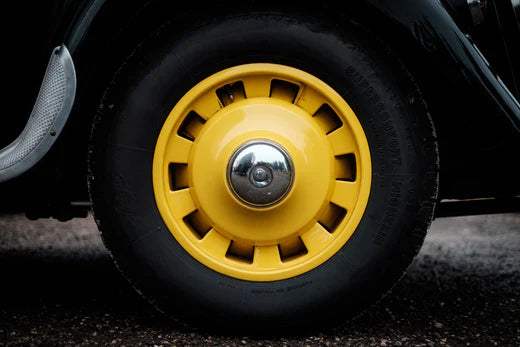 Classic vehicle wheel with a yellow hubcap showing the type of wheel assembly where air springs could be integrated for improved suspension